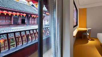 A room with a traditional Chinese architectural view through a window, a modern desk, and a chair.