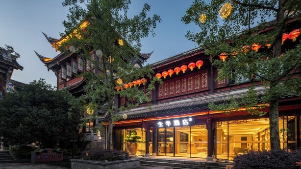 A traditional building with a tiled roof, large windows, and a sign indicating a hotel. - Ji Hotel Chongqing Bishan Cbd Xiuhu Park (Chongqing)