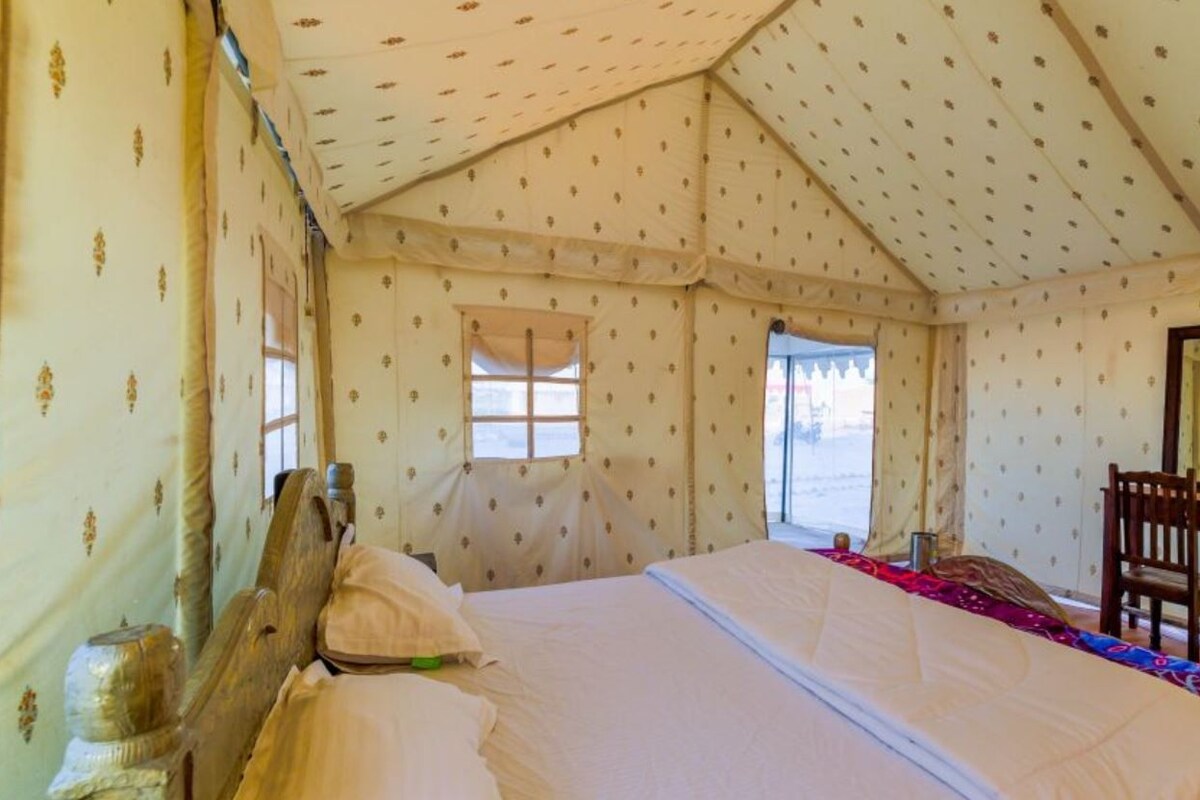 Una camera a tenda con un letto, una scrivania e una sedia.