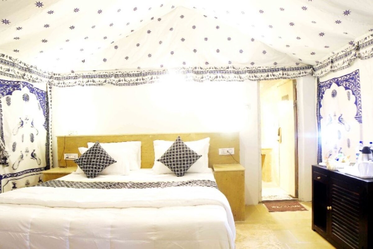 Una camera d'albergo con un letto, comodini, una cassettiera e vista sull'esterno.