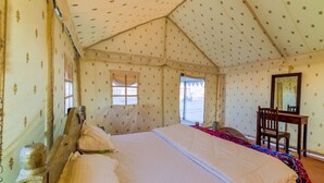 Une pièce aménagée comme une tente, avec un lit, un bureau et une chaise.