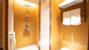 A bathroom with a shower, a towel rack, and a toilet.
