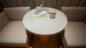 A round table with a white marble top, surrounded by beige cushioned seating. - Ji Hotel Zhengzhou Agricultural Road Shenglong Tia (Zhengzhou)