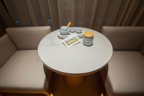 A round table with a white marble top, surrounded by beige cushioned seating. - Ji Hotel Zhengzhou Agricultural Road Shenglong Tia (Zhengzhou)