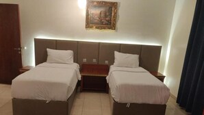 A double bed room with a headboard, a bedside table, a rug, and a painting on the wall. - Golden Dana Agadir (Jizan)