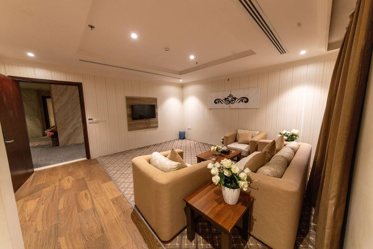 Una sala de estar moderna con un conjunto de sofá, una mesa de centro y un televisor de pantalla plana montado en la pared.