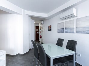 Ein moderner Konferenzraum mit einem Glastisch, schwarzen Stühlen und einer Whiteboard-Wand.