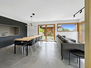 A modern kitchen with a dining area, large windows, and a view of a mountainous landscape. - Chalet Commaraf! - Swiss Alp 4 Vallées by Interhome (Savièse)