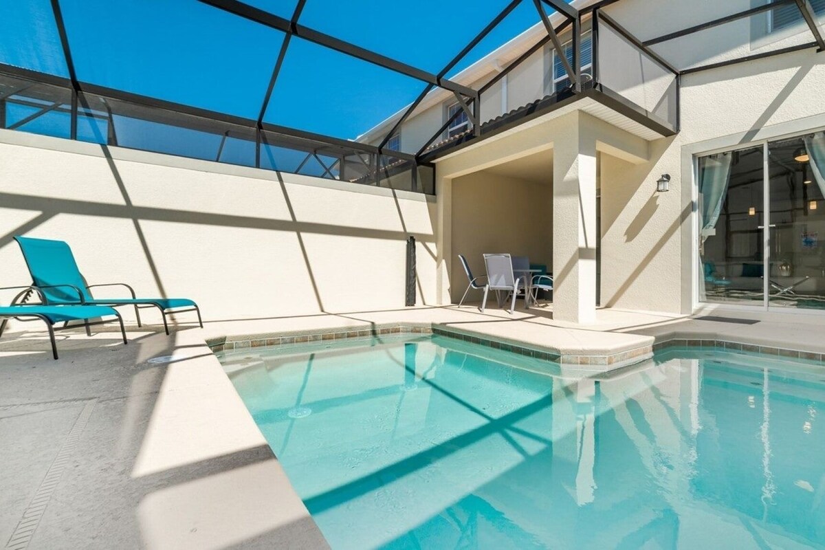 A swimming pool with blue water, surrounded by white walls and a glass ceiling.