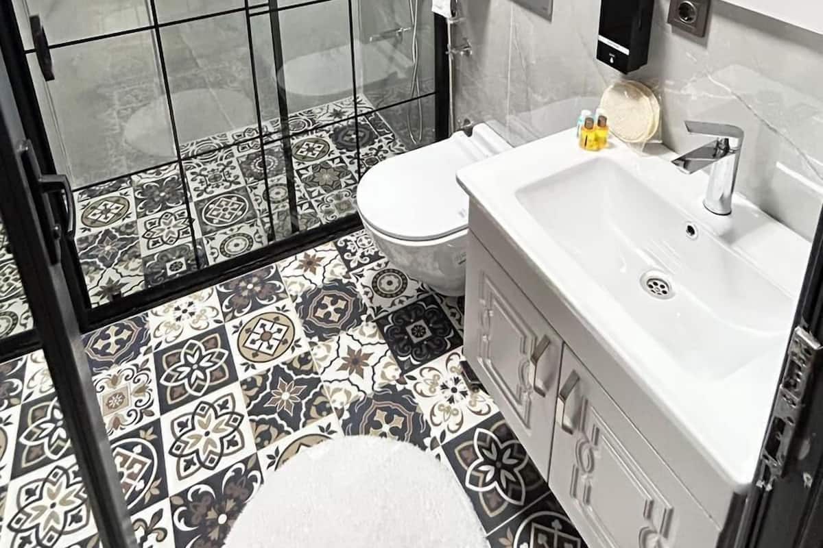 A modern bathroom with a shower, toilet, and sink.