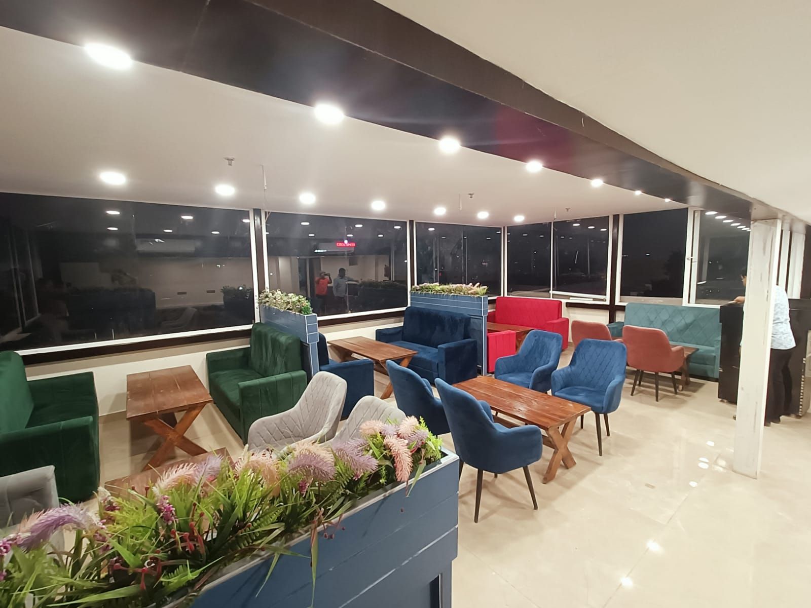 A modern lounge area with multiple seating options, large windows, and a clean, well-lit interior.