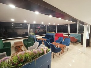 A modern indoor seating area with multiple chairs and tables, large windows, and a clean, well-lit environment. - Amritara Kirpa, Amritsar Golden Temple (Amritsar)