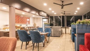 Un comedor moderno con sillas azules, una mesa de madera y un ventilador de techo.