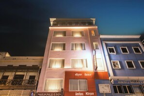 Un edificio de varios pisos con letreros que indican los hoteles 'Amritara' y 'Kirpa'.