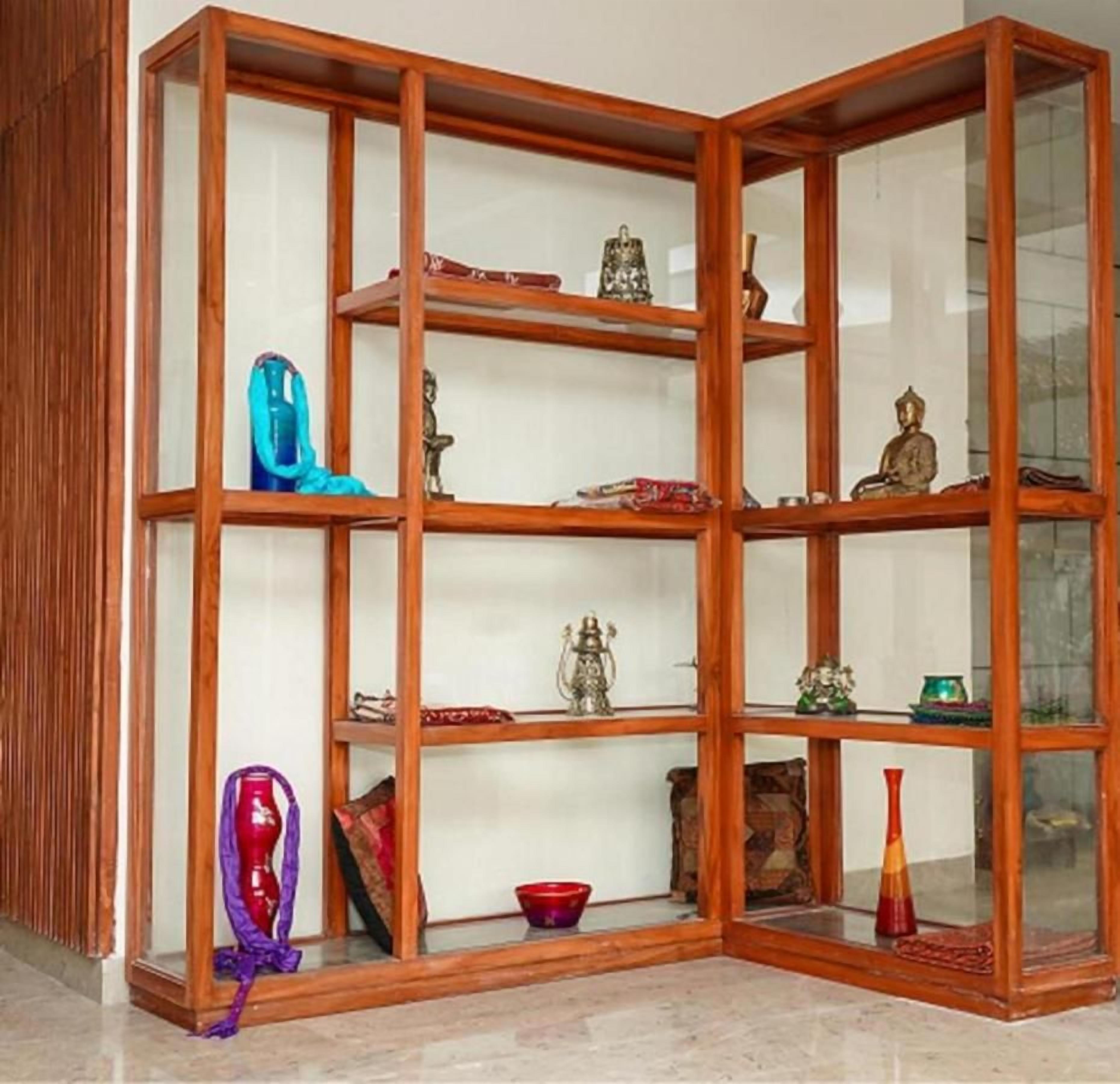 A corner room with a wooden shelving unit displaying various decorative items.