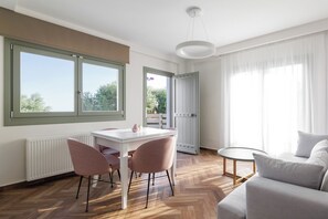 Una sala de estar moderna con comedor, ventanas amplias y vistas al exterior.