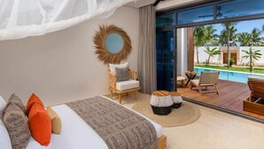 Ein Schlafzimmer mit einem Bett, einem Sessel, einem runden Spiegel und Blick auf einen Pool.