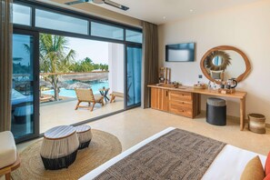 A bedroom with a large window, a wooden desk, a TV, a mirror, and a bed. - Kwanza Resort (Kizimkazi)