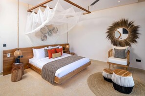 A bedroom with a wooden bed, a canopy, a round mirror, and a chair with a cushion.