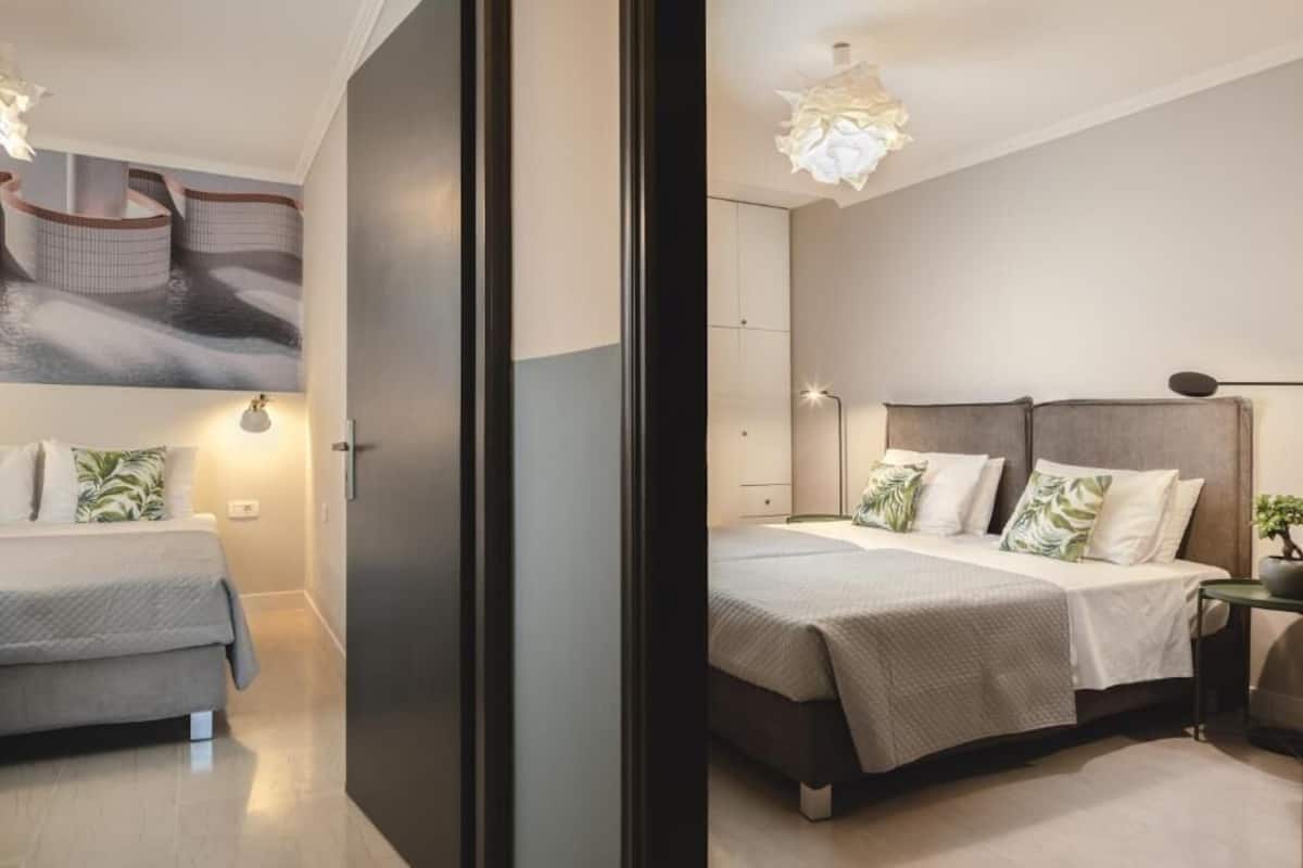 A modern bedroom with a bed, bedside tables, and a wall-mounted shelf.