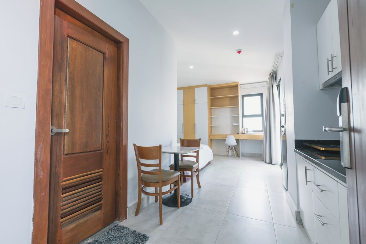 Una cocina moderna con comedor, armarios de madera y un gran ventanal.