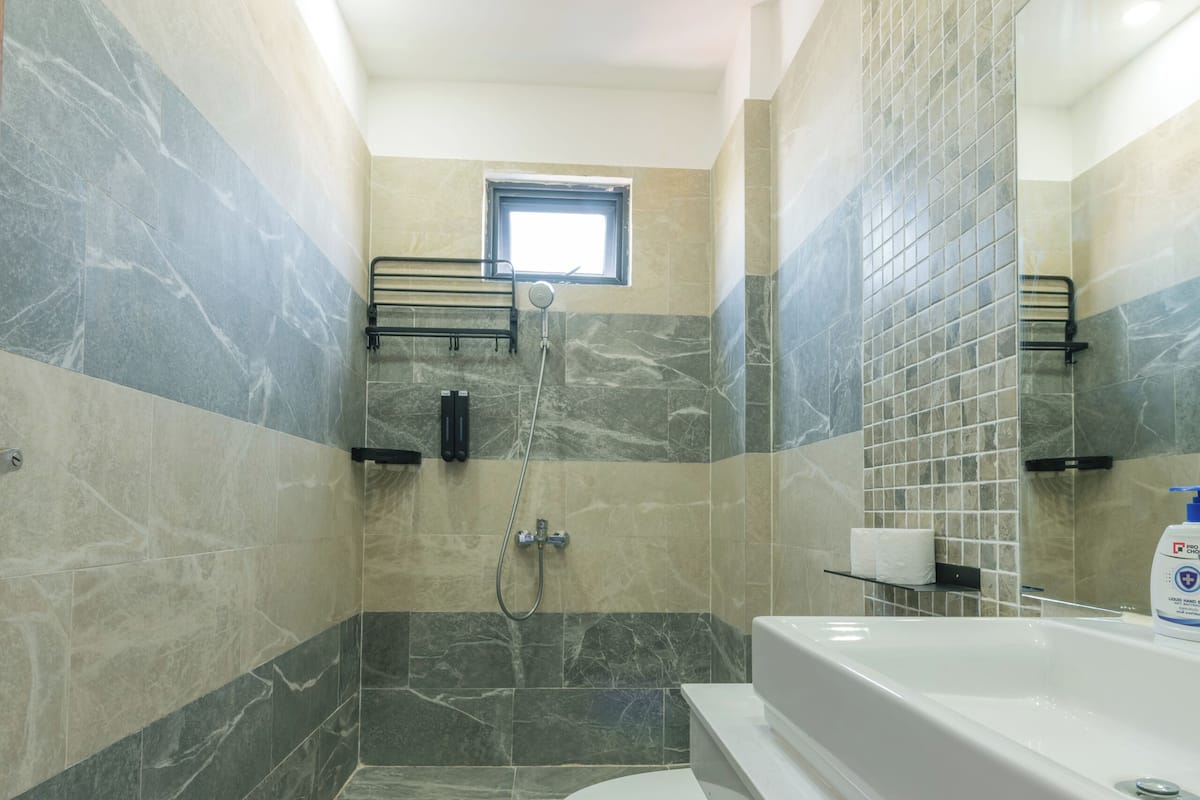 A modern bathroom with a shower, toilet, and bathtub.