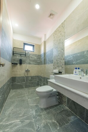 Un baño con inodoro, ducha y lavabo.
