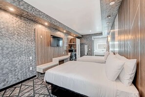 Une chambre d’hôtel avec un grand lit, un bureau et un téléviseur fixé au mur.