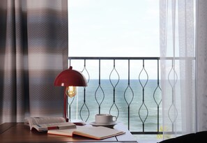 A room with a view of the sea, a table with books and a cup, and a red lamp. - Blue Ay Boutique Hotel (Atakum)