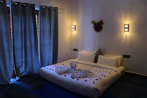 Una habitación de hotel con una cama bien hecha, un aplique de pared y un adorno decorativo en la pared.