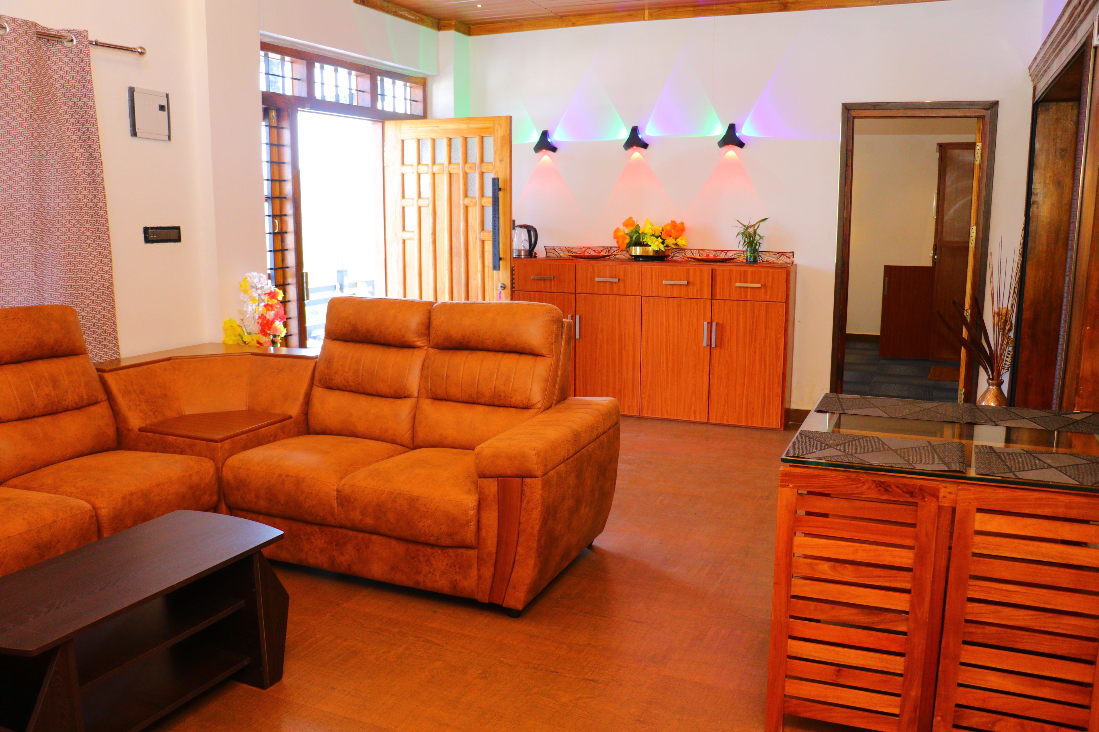 A living room with a sofa, a coffee table, wooden cabinets, and a decorative plant.