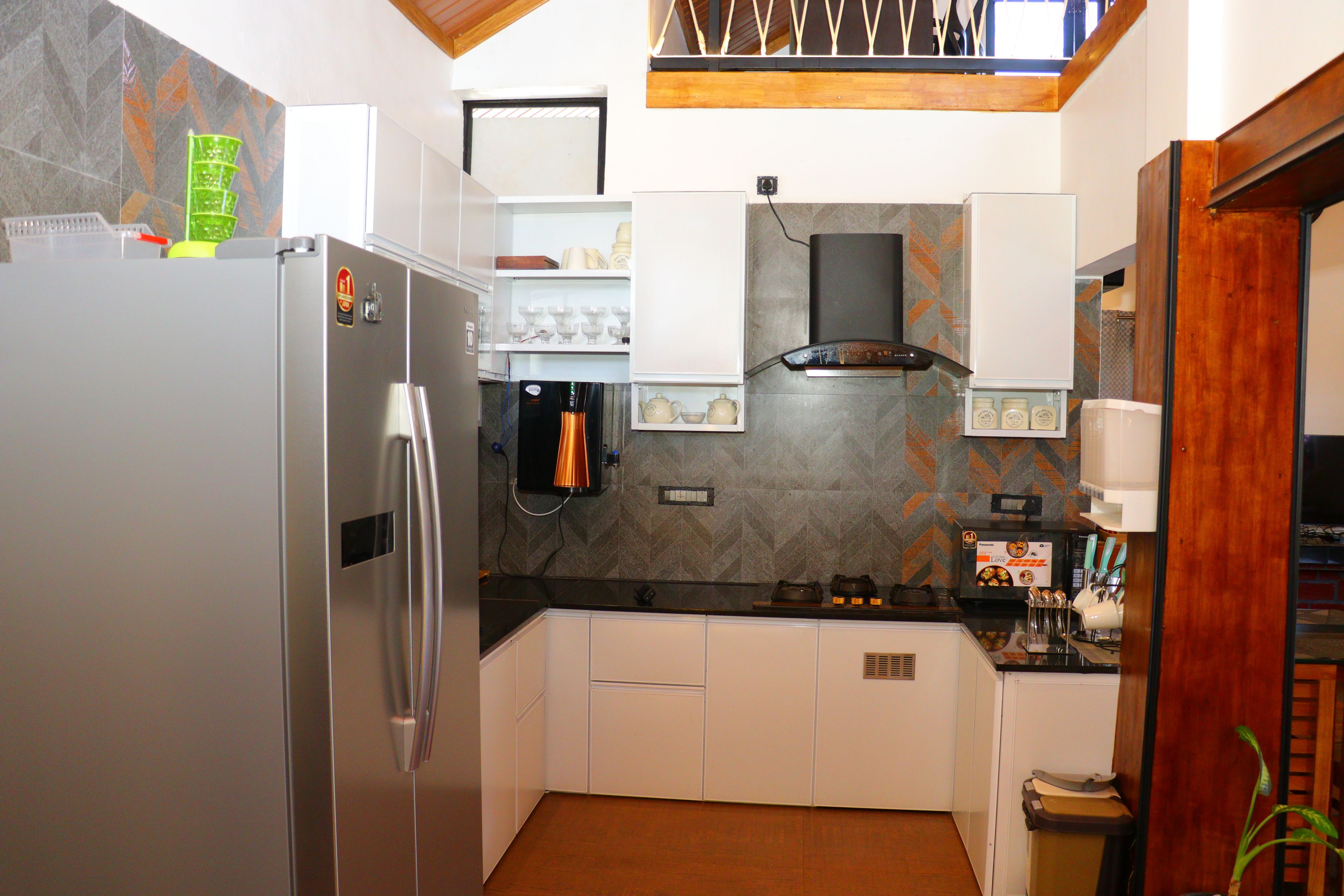 A kitchen with a refrigerator, oven, and microwave. There are cabinets and a countertop.