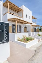 Un edificio moderno con fachada blanca, pérgolas de madera y un letrero que dice 'LOVES NOVE LOS LUXURY'.