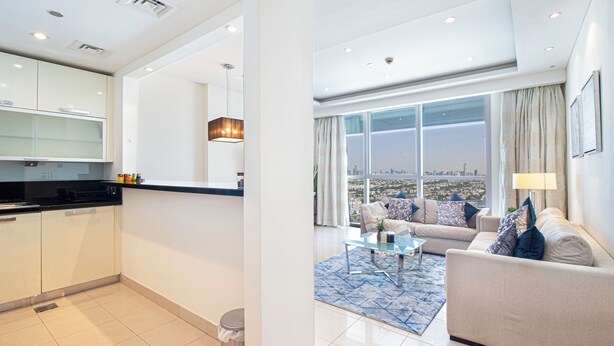 Un apartamento moderno con cocina, sala de estar y ventanas amplias que ofrecen vistas a la ciudad.