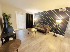 Ein Wohnzimmer mit einer Couch, einem Couchtisch und einer Lampe.