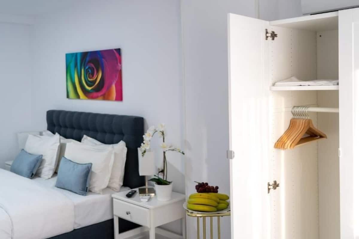A bedroom with a bed, bedside table, and a wardrobe.