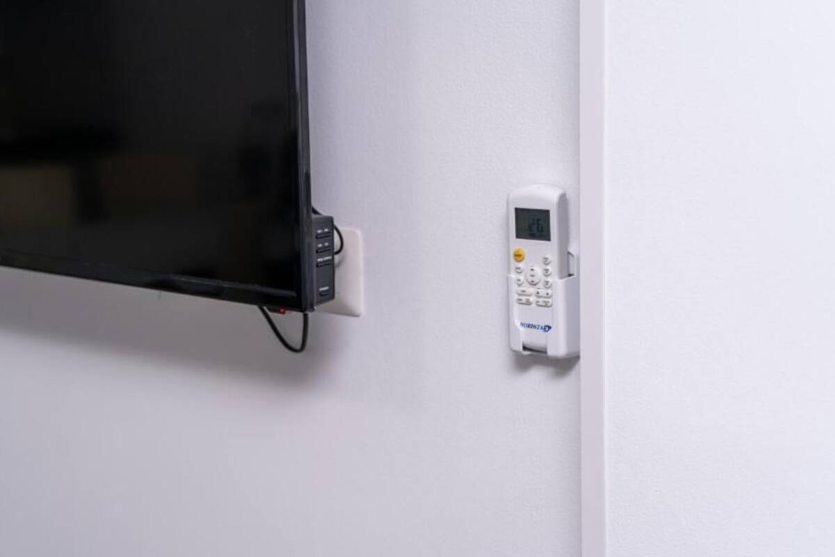 A wall-mounted television and a control panel, likely for a security system.