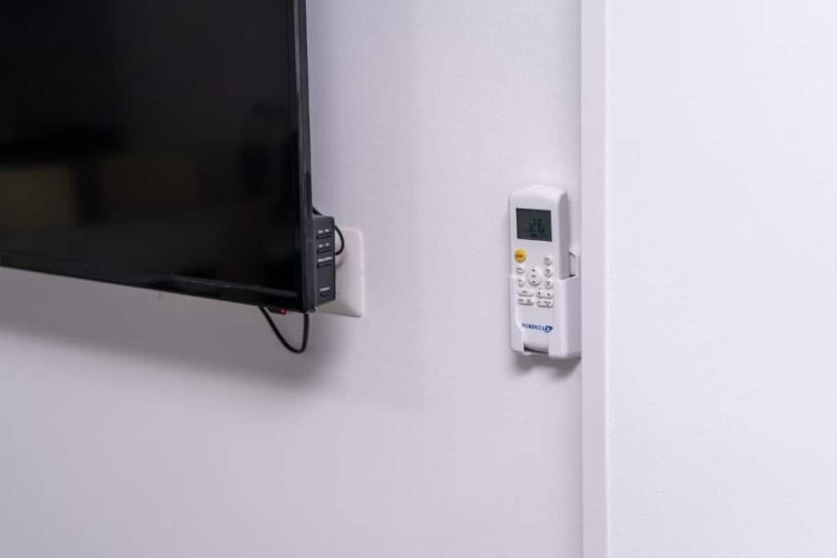 A wall-mounted television and a control panel, likely for a security system.