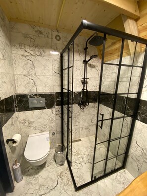 A bathroom with a glass-enclosed shower, a toilet, and a marble-tiled floor. - Berva Bungalow (Çamlıhemşin)