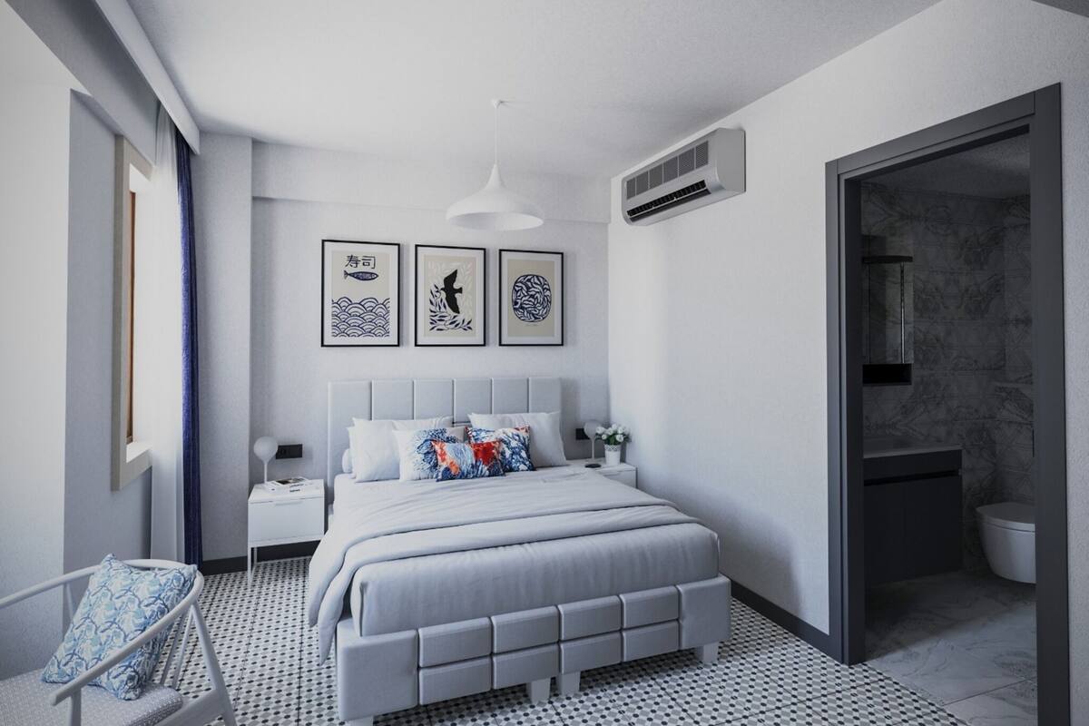 Ein modernes Schlafzimmer mit einem Bett, Nachttischen, einem Sessel und Bildern an der Wand.