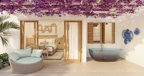 Een moderne slaapkamer met een bed, een grote ronde wastafel en een bloemenarrangement dat aan het plafond hangt.