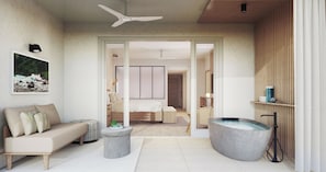 A modern bedroom with a bed, a sitting area with a sofa, a large bathtub, and a ceiling fan.