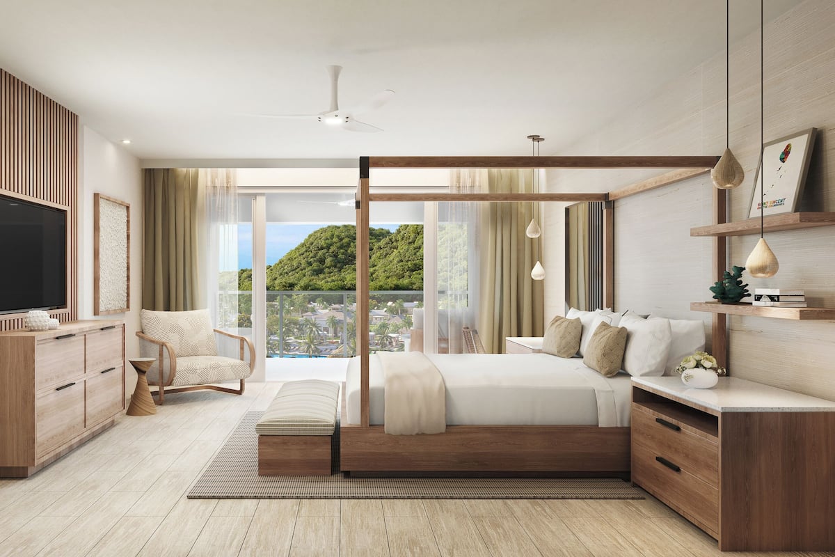 A modern bedroom with a large bed, a TV, a chair, and a view of a green landscape.