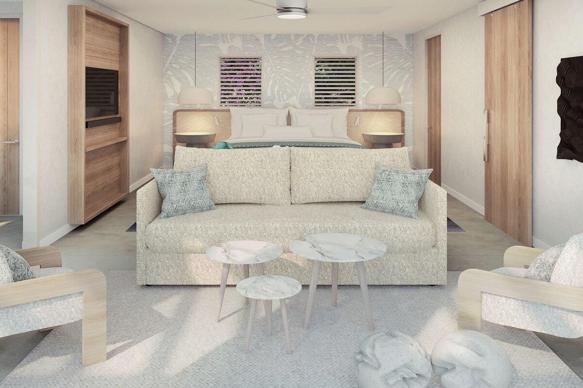 A modern bedroom with a sofa, two side tables, a bed with a headboard, and a wardrobe.