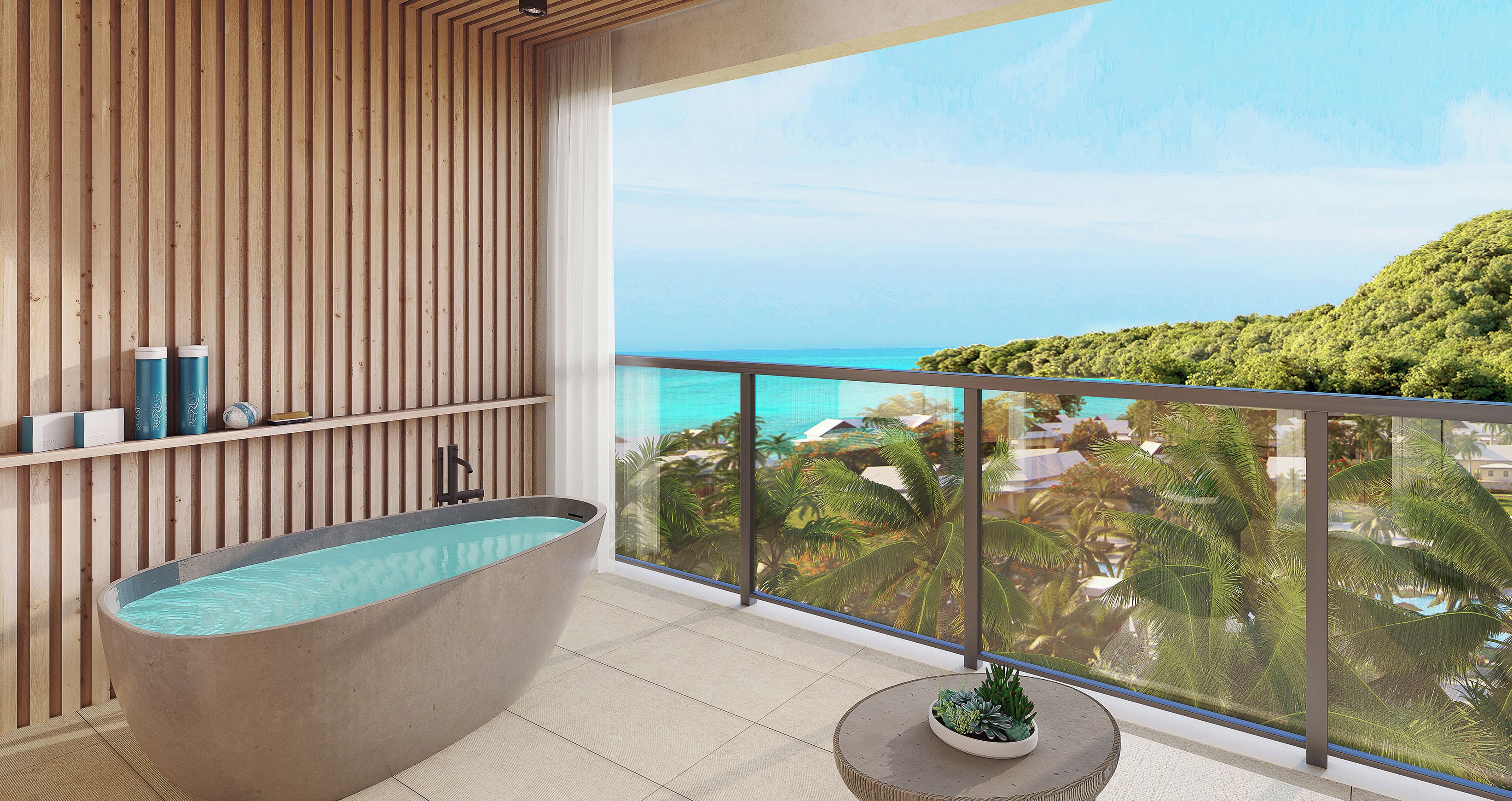 A modern bathroom with a freestanding bathtub, a small potted plant, and a balcony with a view of the ocean and greenery.