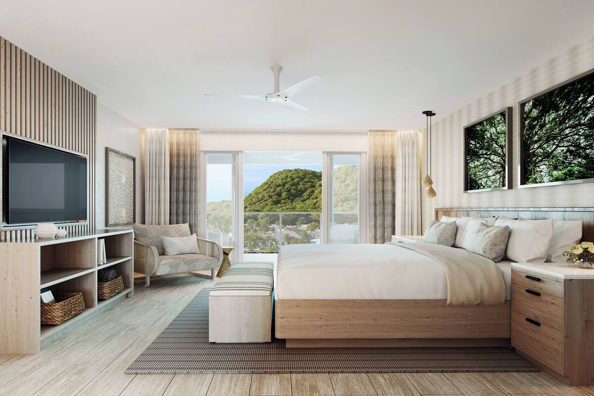 Quarto moderno com cama grande, televisão, estantes de madeira e vista para o verde.
