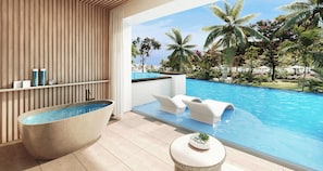 A modern bathroom with a freestanding bathtub, a small round table with a plant, and a view of a pool with palm trees.