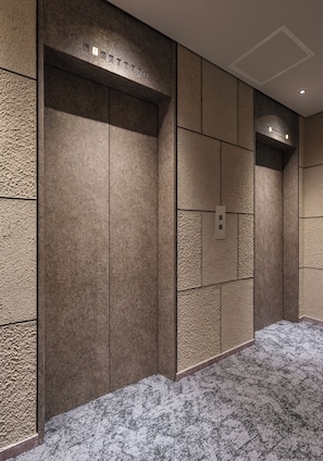 A modern elevator with a textured wall design and a control panel. - Villa Tokyo Season Ryogoku (Sumida)