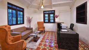 A room with a sofa, armchair, desk, and patterned floor. - Arova Woods Zinc Journey (Mawal)