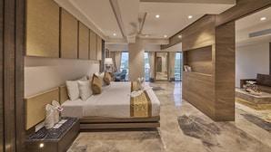 A modern hotel room with a large bed, a desk, and a view of the outdoors. - Regenta Central Imperial Candolim (Candolim)